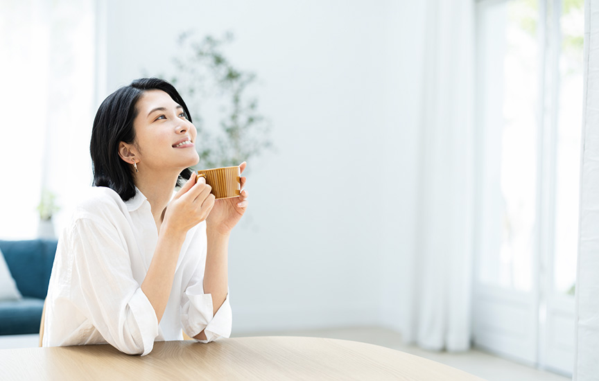写真：飲み物を飲んで休憩している女性のイメージ