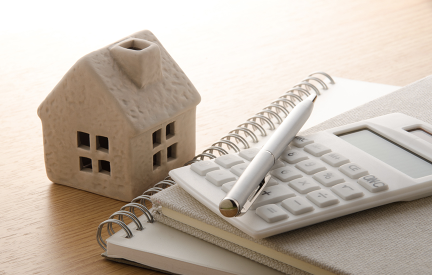 写真：家の模型と電卓