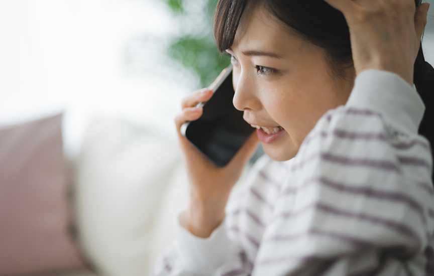写真：焦って電話する女性
