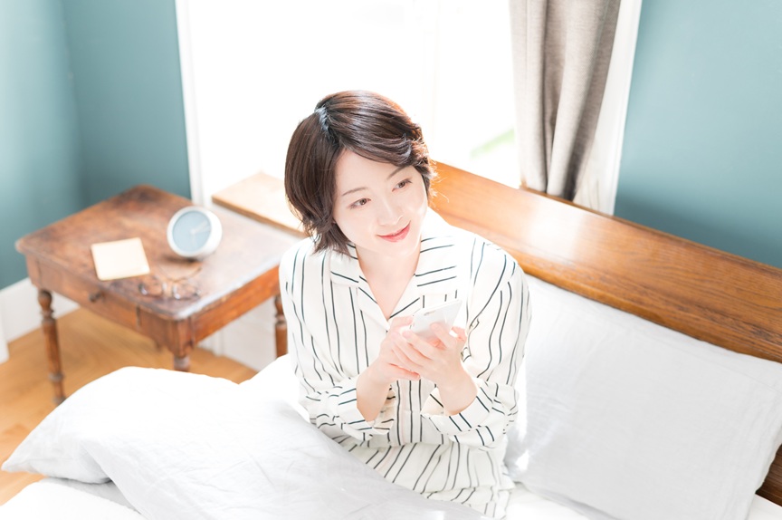 画像：ベッドに座っている女性