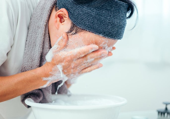 男性が洗顔しているイメージの写真