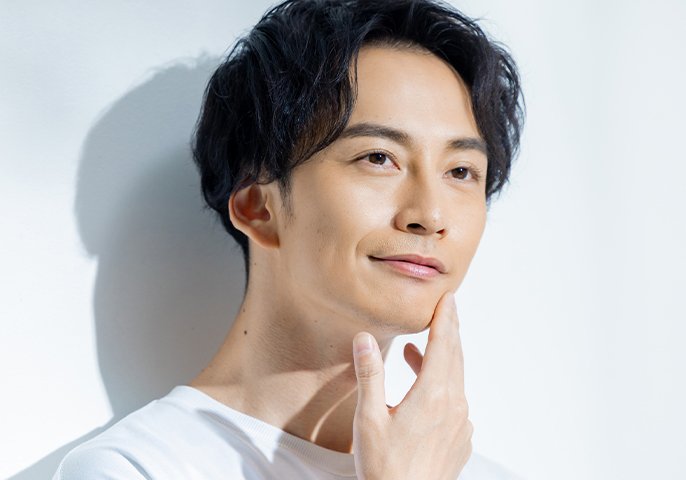 頬に手をあてている男性のイメージの写真