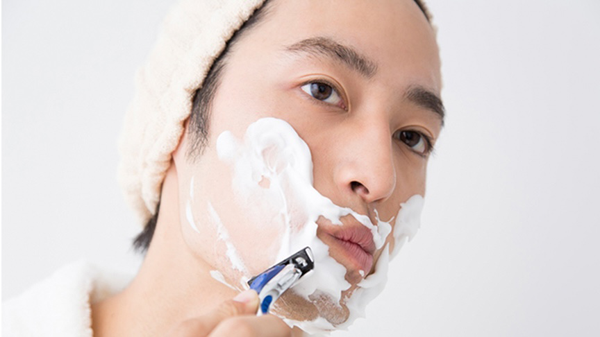 写真：男性がT字カミソリで髭を剃っている様子
