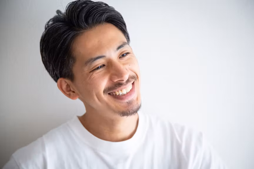 ヒゲが生え笑っている男性