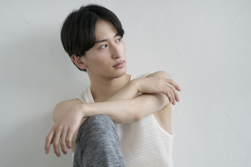腕を組んで座っている男性の様子数の写真