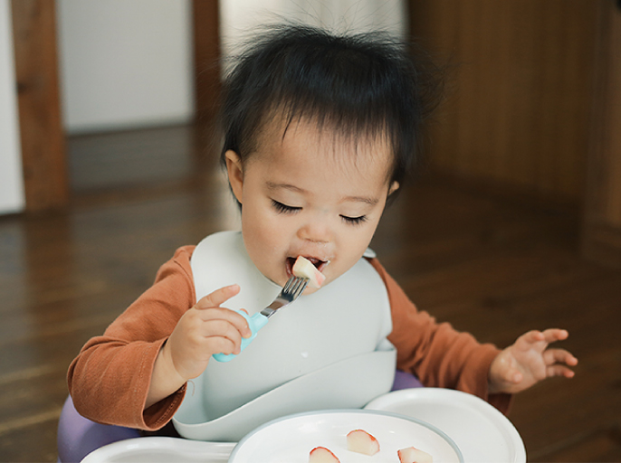 イメージ：子どもがフォークを使って自分で食事する様子