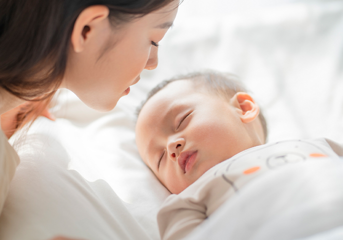 イメージ：寝ている赤ちゃんを見ている女性