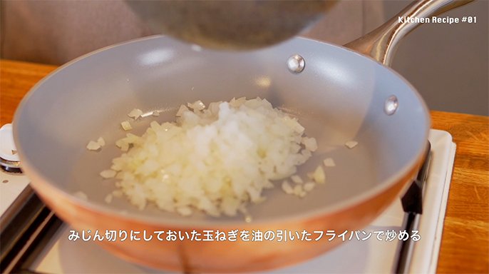写真：みじん切りにした玉葱をフライパンで炒めている