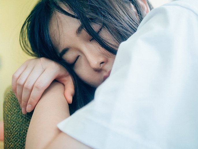 写真：女性が自分の腕を枕にしてうたた寝しているイメージ