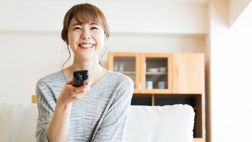 リモコンを操作している女性の写真