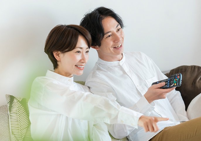 テレビを見る男女の写真