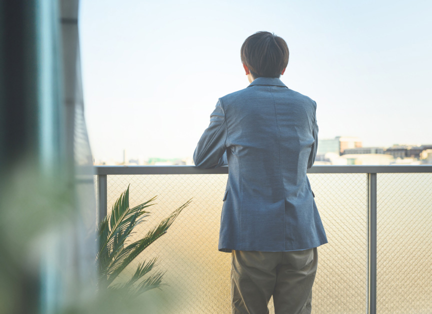 写真：男性が外の景色を見ているイメージ