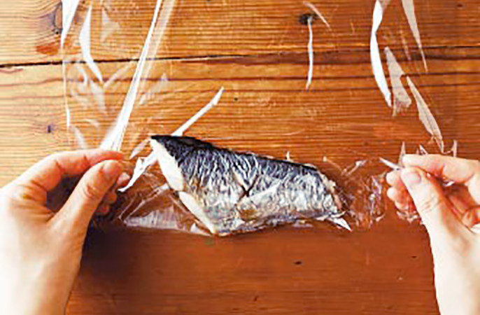 写真:調理済みの鯖をラップで包む