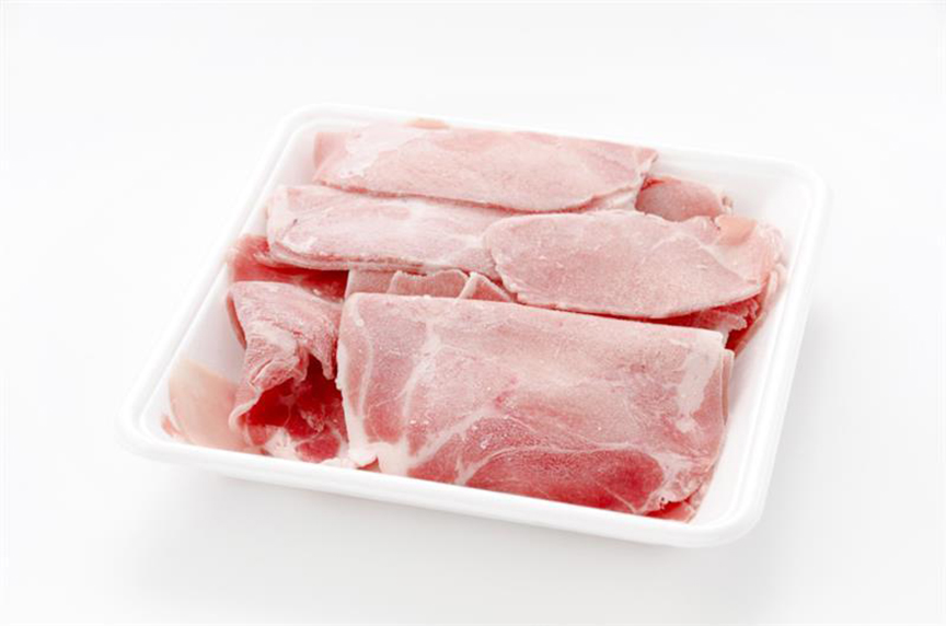 写真：白いトレーに並べられた生の豚肉スライス。