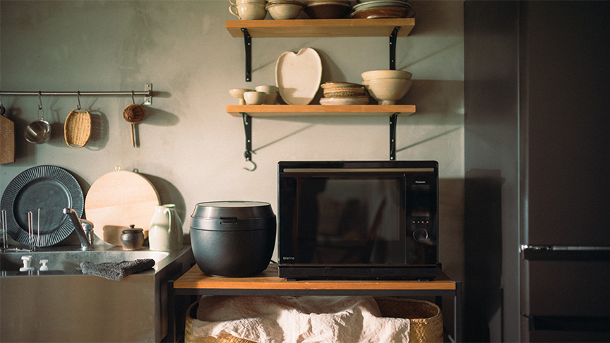 写真：女性が電子レンジを使用しているイメージ