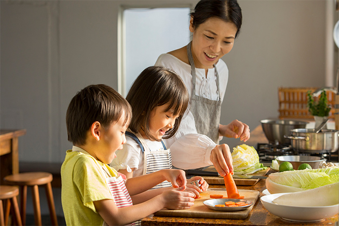写真：一緒に料理をする母親と子ども二人