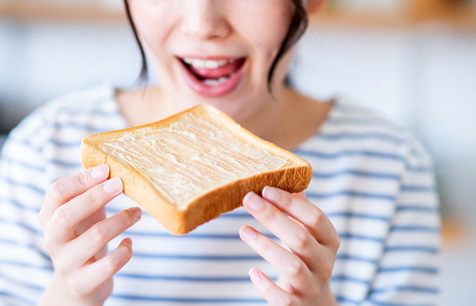 パンを食べようとしている女性の写真