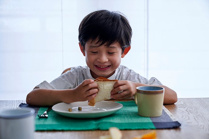 食パンを食べている子どもの写真