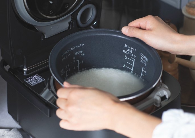 写真：炊飯器にお米をセットして炊く準備をしているイメージ