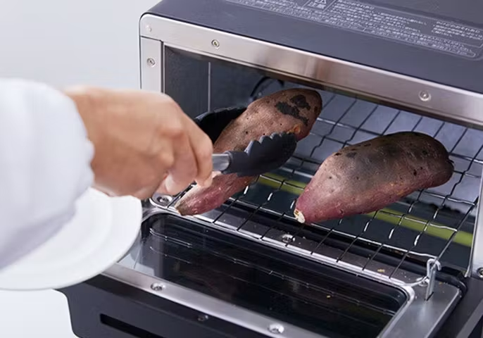 写真：トースターに焼き芋を入れてるイメージ