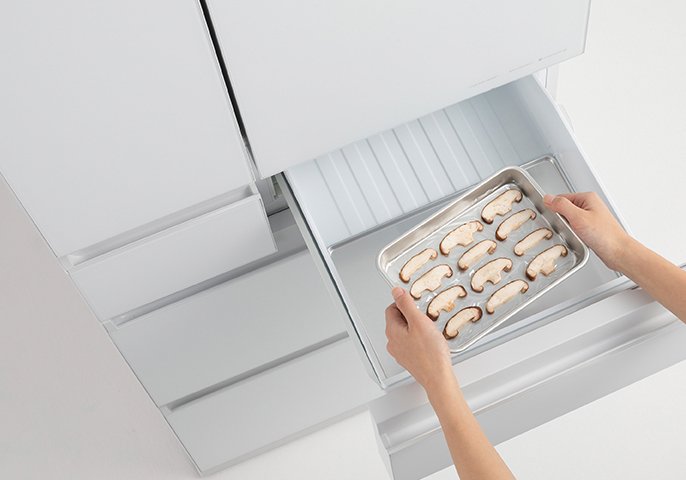 写真：パナソニックの「はやうま冷凍」搭載の冷蔵庫にスライスした椎茸を入れようとしているイメージ