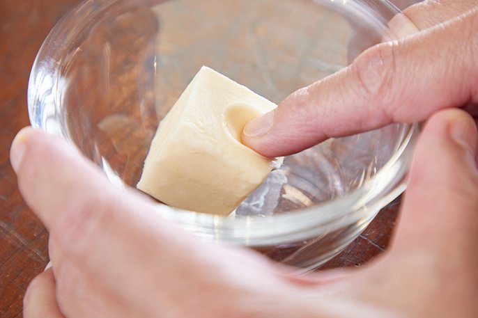 写真：指で押してへこむくらいに柔らかくなったバターのイメージ
