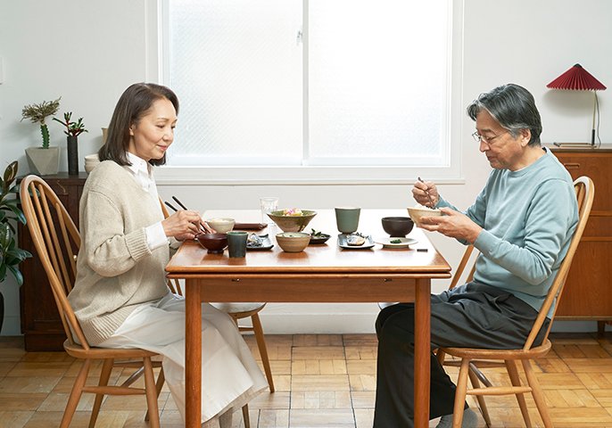 写真：中年夫婦が食卓を囲んでるイメージ