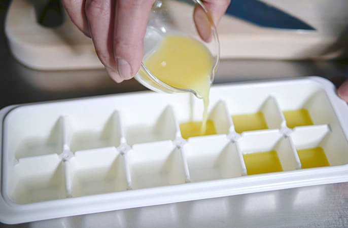 写真：生姜の絞り汁を製氷皿に注いでるイメージ
