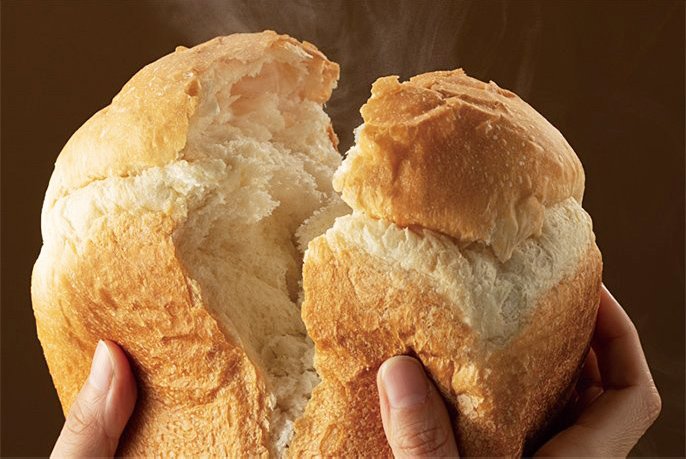 写真：パンを手でちぎってるイメージ