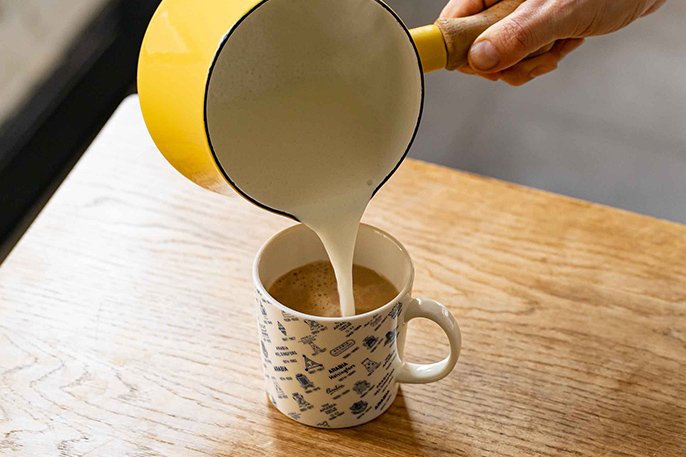写真：コーヒーにミルクを注いでるイメージ