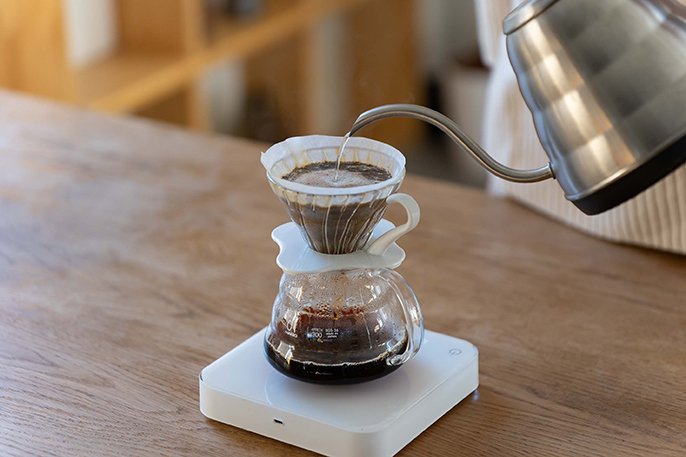 写真：蒸らしたコーヒーにお湯を注いでるイメージ