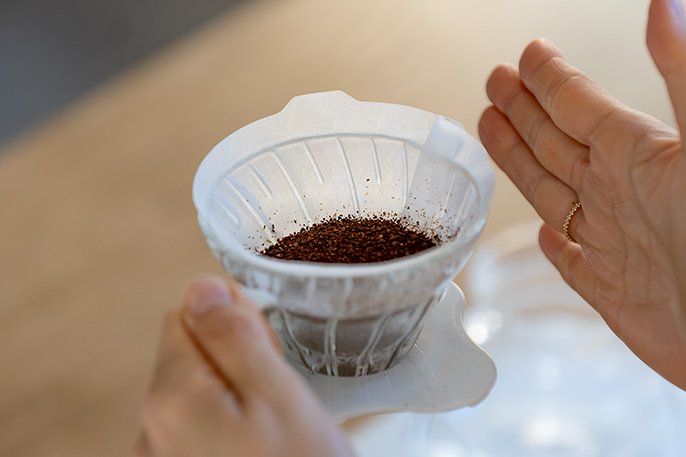 写真：挽いたコーヒー粉を入れてるイメージ