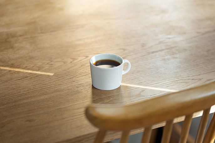 写真：コーヒーが注がれたカップがテーブルに置いてあるイメージ