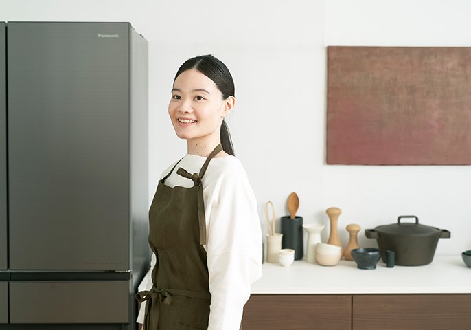 写真：冷蔵庫の前に女性が立っているイメージ