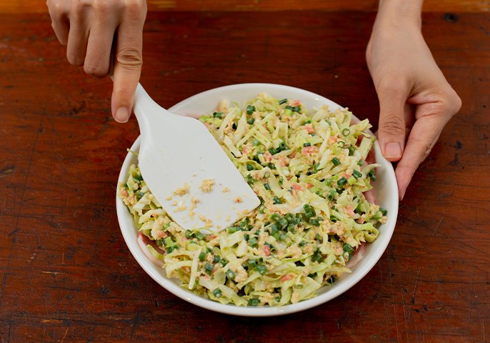 写真：豚肉の上に3をのせ、空気を抜くようにしっかりと押し付けながら、2〜3cm厚さに丸く形を整えているイメージ