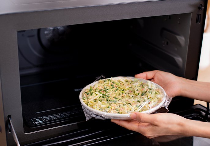 写真：ラップをして電子レンジに入れているイメージ