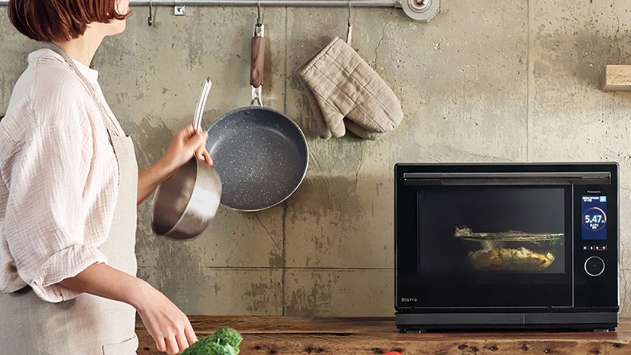 キッチンで料理をする女性とオーブンレンジの写真