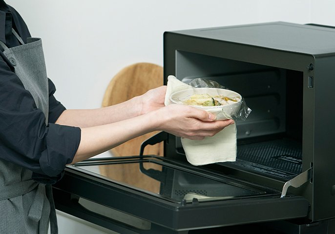 写真：食材を電子レンジに入れているイメージ