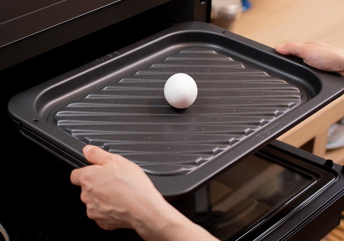 写真：グリル皿を上段に入れ、中央に卵を1個置く。
