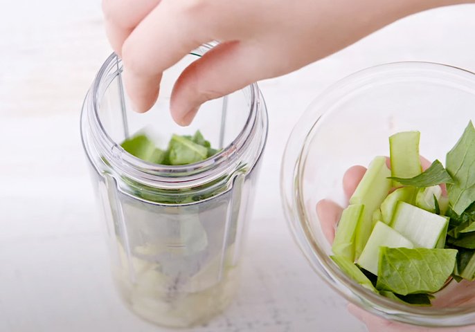 写真：スムージーミキサーに野菜を入れているイメージ