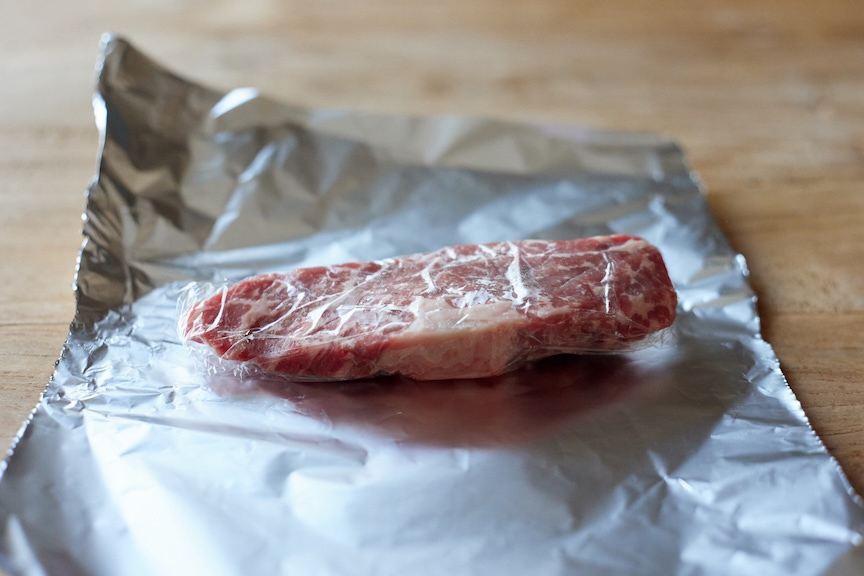 ステーキ肉、ブロック肉がアルミホイルの上に置いてある様子の写真
