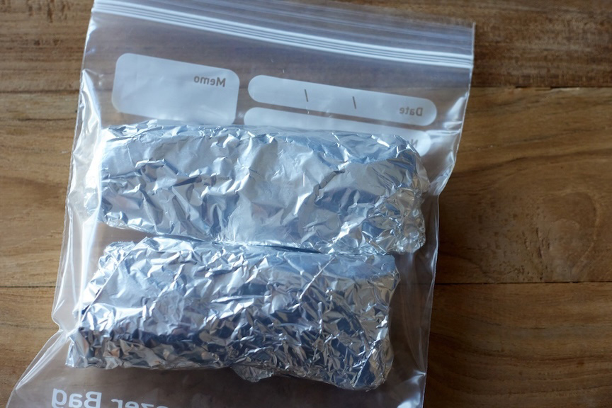 ステーキ肉、ブロック肉をアルミホイルで包んで冷凍用保存袋に入れた様子の写真