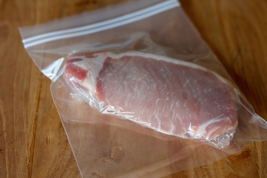 豚ロース肉をラップに包み、冷凍用保存袋に入れた様子の写真