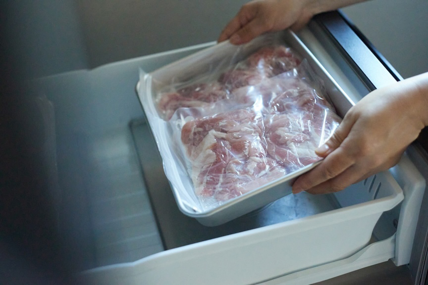 写真：肉を冷凍庫に入れる様子