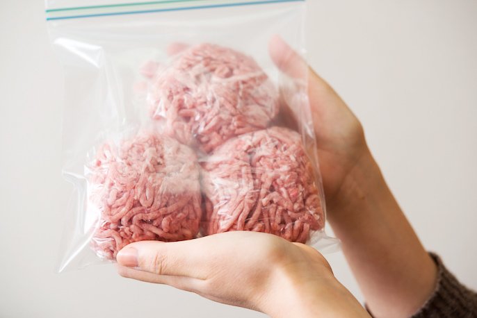 写真：ラップで包まれたひき肉が入っている冷凍用保存袋を、手に持っている様子