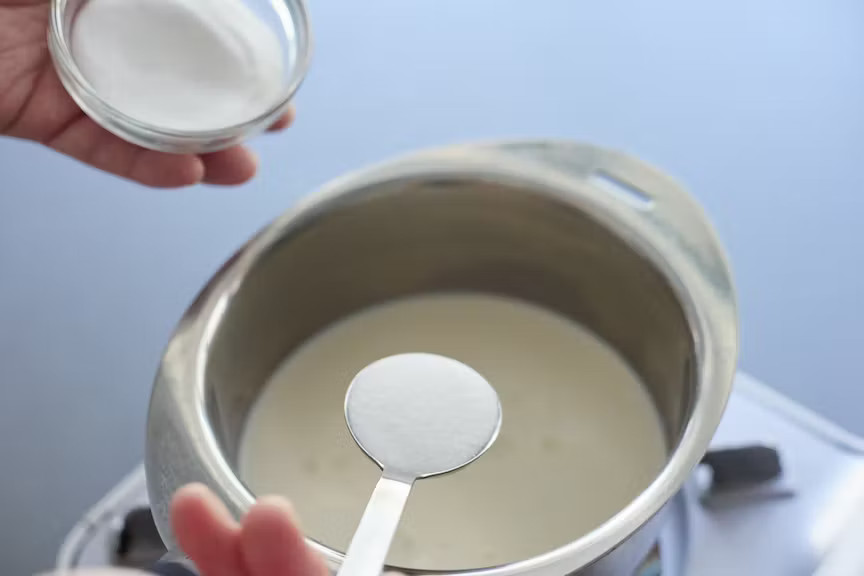 写真：鍋に牛乳とグラニュー糖の1/3を入れる様子