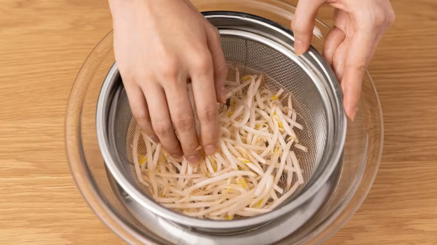 もやしをざるで洗う様子