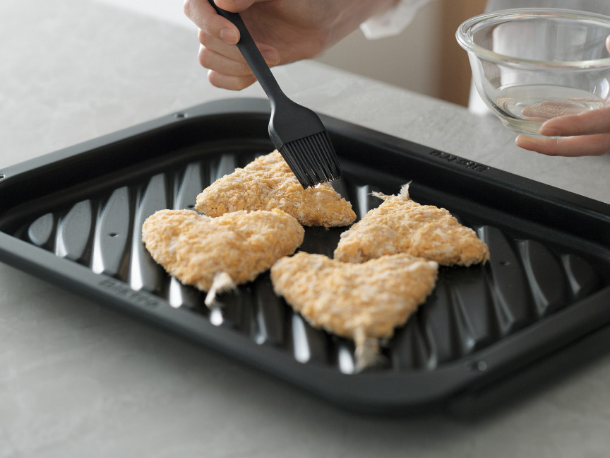 写真：フライに油をつけてヒートグリル皿に並べた様子