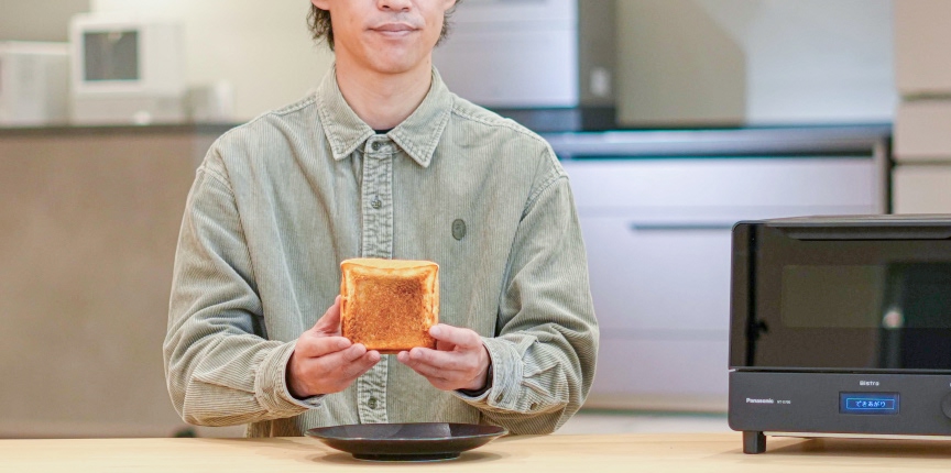 写真：焼いた食パンを持つパナソニック社員Oさん