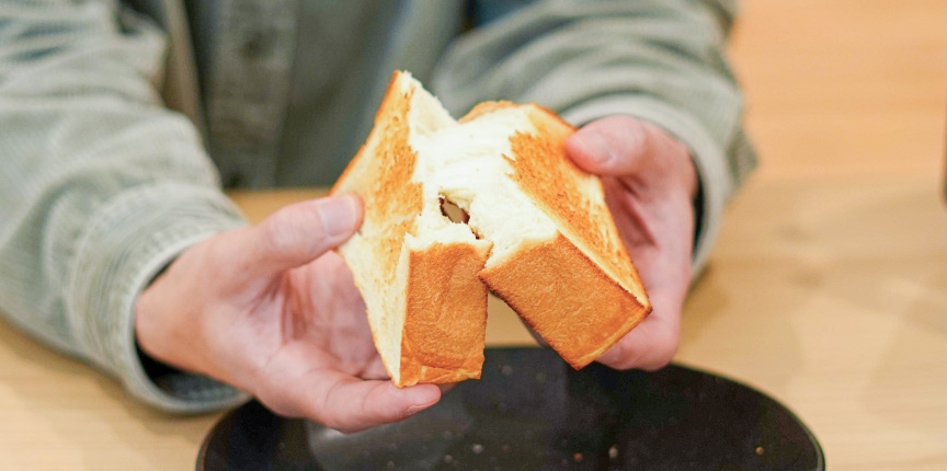 写真：焼きあがったトーストを半分に割いている様子